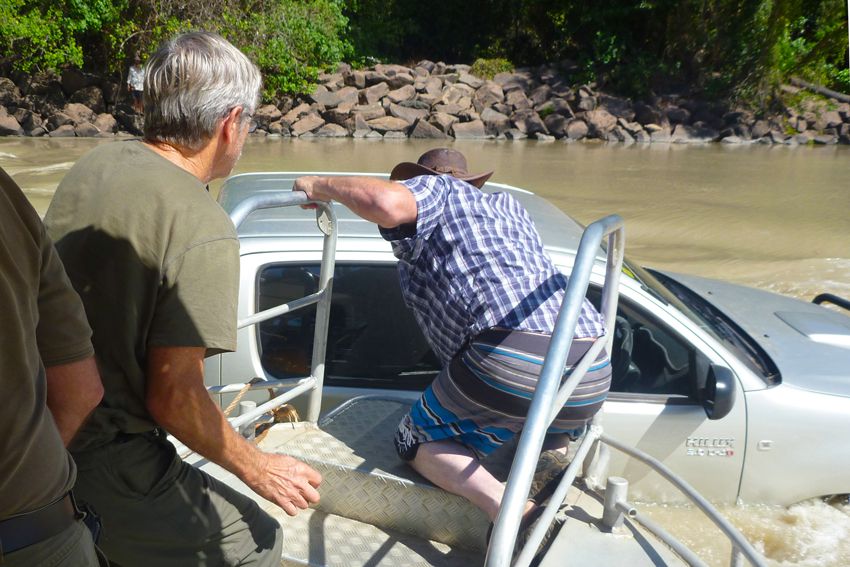 Passenger on the Guluyambi Larry Turner helps the woman out of her Hilux, stranded at Cahill's Crossing. PHOTO: BEV TURNER